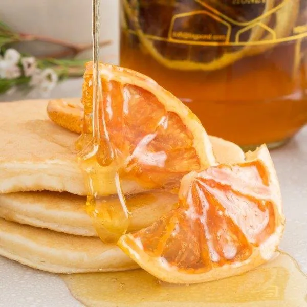 Fruit In Honey 6 F69a3e 600 Dried orange slices in honey on a stack of pancakes